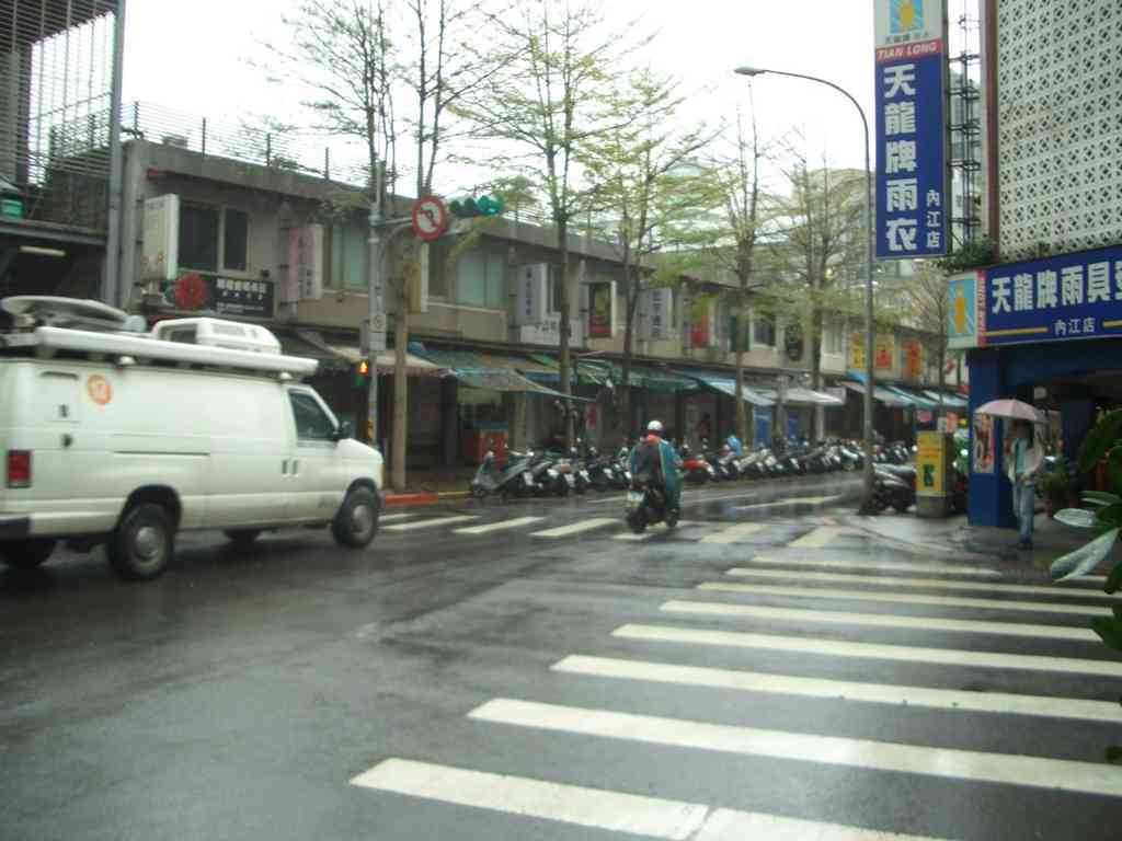The Ximending neighborhood during a light morning shower. Notice the swarms of motor scooters and the shop awnings protecting wares from the rain!