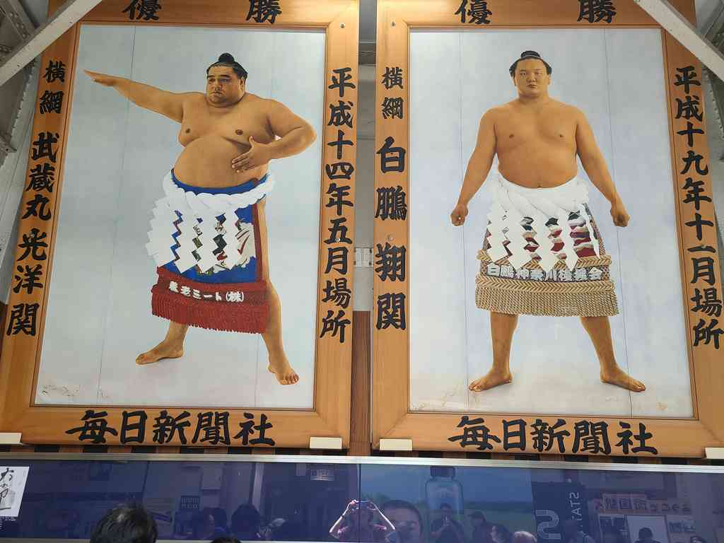Epic portraits of past Yokozunas adorn the top of the stadium. This is the absolute highest, most revered rank a wrestler can achieve.