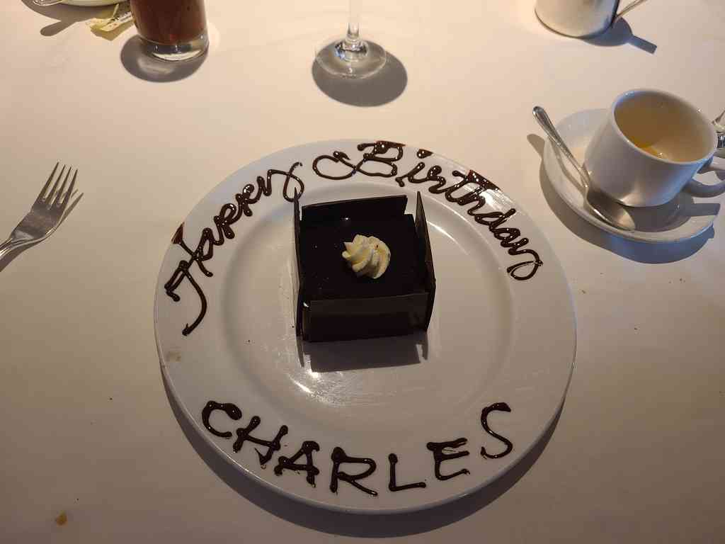 Charles's birthday was actually at the beginning of June before the cruise, but he decided to add it to the 'special occasions' section of the Princess website anyway. He sneakily chose a sea day during the cruise and didn't tell a soul. When the waiters brought the cake out, everyone—including Helen—was completely surprised!
